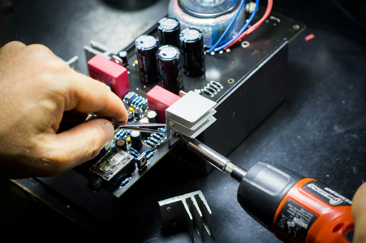 Hands assembling electronics on a circuit board